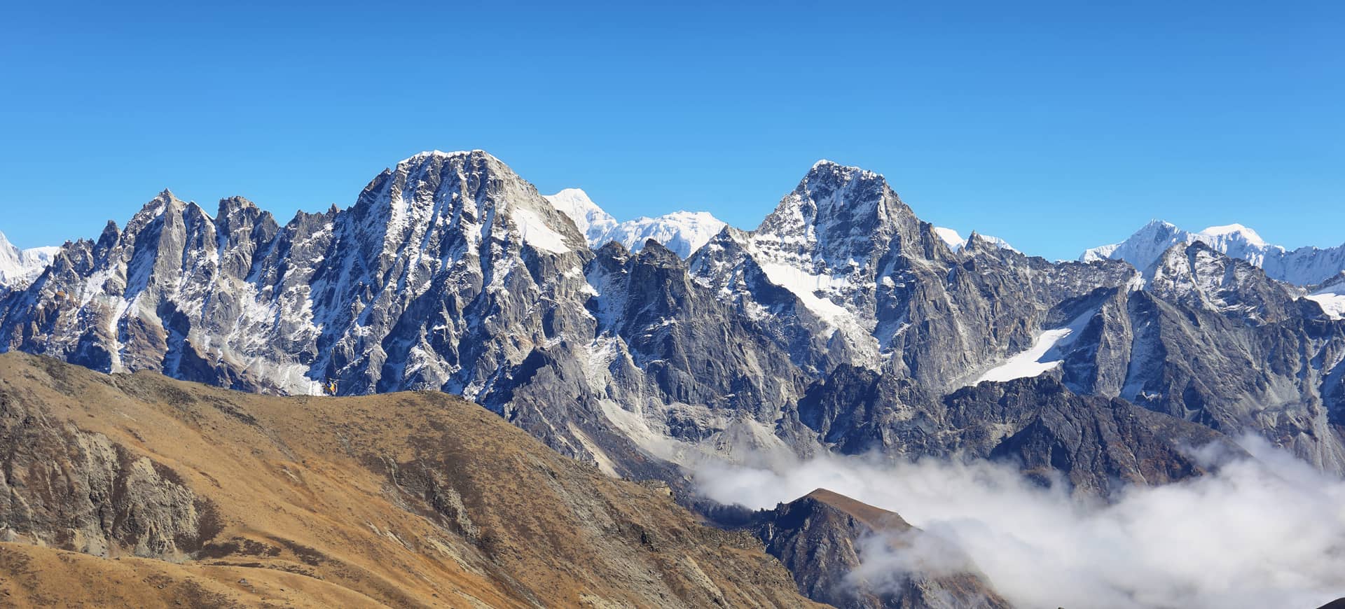 Vista panorâmica dos picos nevados do Himalaia com nuvens ao fundo, Nepal